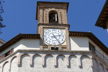 Fototapeta na wymiar Sant'Ercolano church, Perugia. Facade of Sant'Ercolano church, the patron of Perugia, with a double flight of steps and the bell tower with an ancient clock. It is situated in Perugia, Italy.