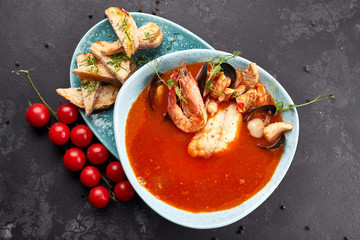 Seafood Tomato Soup, on a dark background, Bouillabaisse