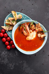 Seafood Tomato Soup, on a dark background, Bouillabaisse