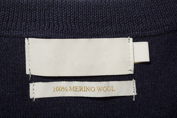 100 merino wool label on the sweater dark blue wool fabric.