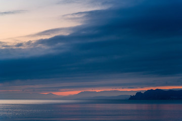 Beautiful sunset in blue clouds on the seashore