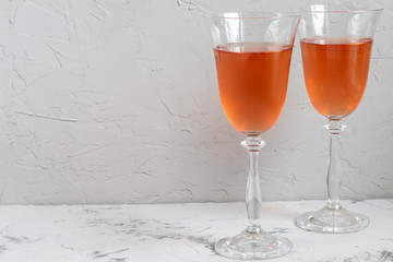 Orange wine is poured into two glasses. Celebratory drink. Family celebration.