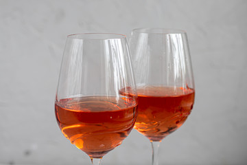 Orange wine is poured into two glasses. Celebratory drink. Family celebration.