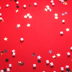 Christmas background with stars and marshmallows on red.