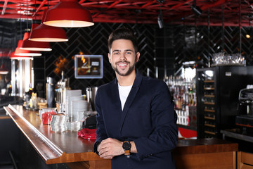 Young business owner standing near counter in his cafe