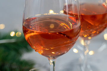 Orange wine is poured into two glasses. Celebratory drink. Family celebration.