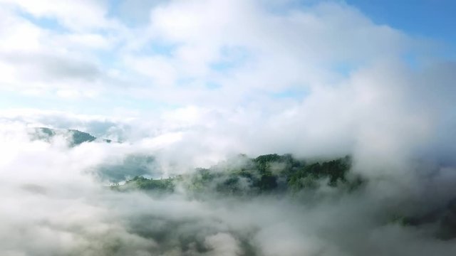 Flight in the clouds in mountains, morning clouds in the mountains aerial, aerial view of morning fog in mountains, Aerial view above the clouds and sky in sunrise time, Majestic clouds in the mountai