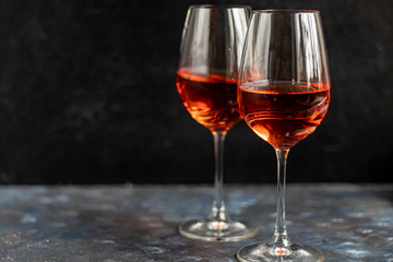 Orange wine is poured into two glasses. Celebratory drink. Family celebration.