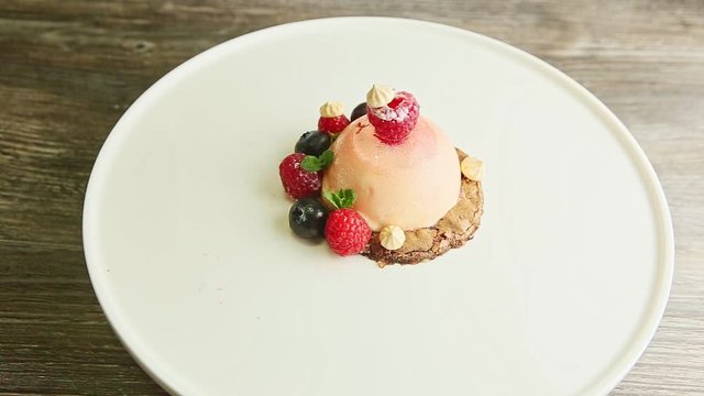 zoom out from icing dessert finely decorated with berries rotates on plate