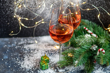 Orange wine is poured into two glasses. Celebratory drink. Family celebration.