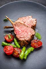 Barbecue rack of lamb neck with paprika and tomato offered as closeup on a modern design plate