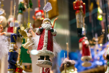 Shop window with festive hanging Christmas decorations, including a Santa Claus.