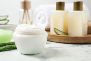 Fototapeta na wymiar Open jar of aloe cream on white marble table. Organic cosmetics