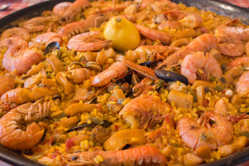 Seafood paella closeup. Delicious seafood meal. Mediterranean cuisine. Paella pan with king shrimps, mussels, saffron and calamari. Tasty spanish dinner. Traditional mediterranean food.   