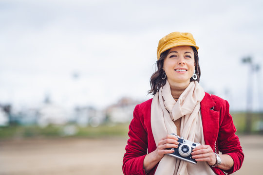 Smiling girl with a retro camera outdoors