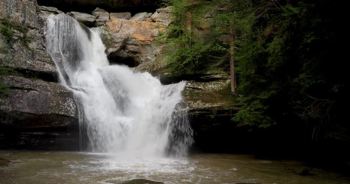 Water cascades and plunges over a sandstone cliff and down Cedar Falls, a beautiful waterfall in the Hocking Hills of Ohio, in this seamlessly looping video background