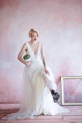 Fototapeta na wymiar Fashionable, beautiful bride with an unusual flower in her hand.