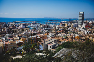 Fototapeta na wymiar Beautiful wide aerial view of Alicante, Valencian Community, Spain with port of Alicante, beach and marina, with mountains and skyline, seen from Santa Barbara Castle on Mount Benacantil, sunny day