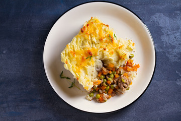 Shepherd's Pie or Cottage Pie on plate, gray backgroud. Overhead horizontal image