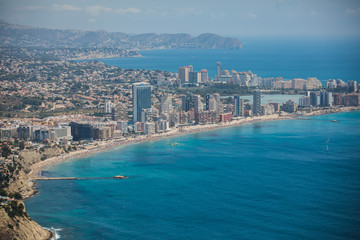 Beautiful super wide-angle aerial view of Calpe, Calp, Spain with harbor and skyline, Penon de Ifach mountain, beach and scenery beyond the city, seen from Mirador Monte Toix mountain viewpoint