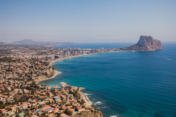 Naklejka premium Beautiful super wide-angle aerial view of Calpe, Calp, Spain with harbor and skyline, Penon de Ifach mountain, beach and scenery beyond the city, seen from Mirador Monte Toix mountain viewpoint