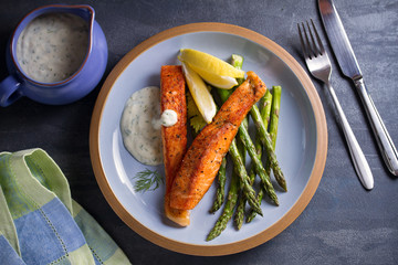 Delicious cooked salmon fish fillets with asparagus and lemon wedges