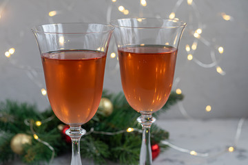 Orange wine is poured into two glasses. Celebratory drink. Family celebration.