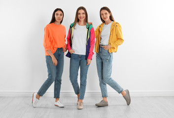 Fototapeta premium Group of young women in stylish jeans near white wall