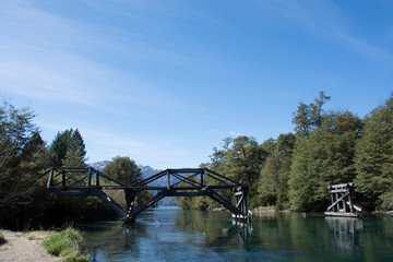 Panoramic view of old wooden bridge over colorful Ruca Malen river during spring season in Nahuel Huapi National Park, Patagonia, Argentina