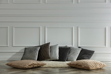 Pillows on floor and white wall background.Free space for your decoration. 