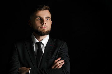 Handsome young businessman on dark background