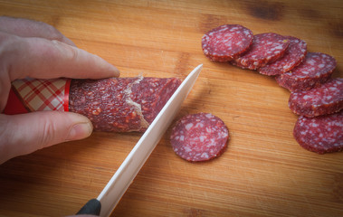 slicing smoked sausage slices on a Board with a knife