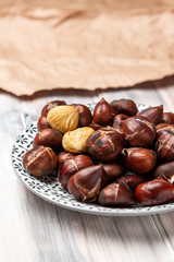 Roasted chestnuts on a plate on a wooden background