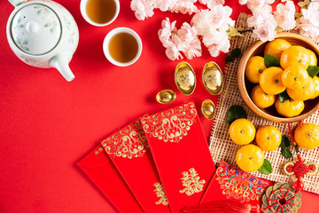 Fototapeta na wymiar Chinese new year festival decorations pow or red packet, orange and gold ingots or golden lump on a red background. Chinese characters FU in the article refer to fortune good luck, wealth, money flow.