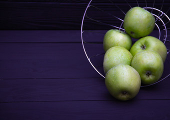 Green apples with water drops on black background.