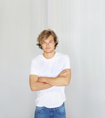 Teenager standing near white wall	