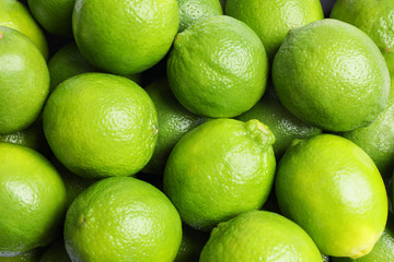 Fresh ripe green limes as background, top view