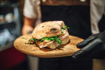 Fresh ciabatta bread sandwitch with meat and rucola, chef making snacks - obrazy, fototapety, plakaty