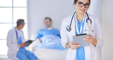 Female doctor using tablet computer in hospital lobby