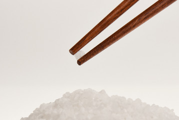 chopsticks with salt on gray background