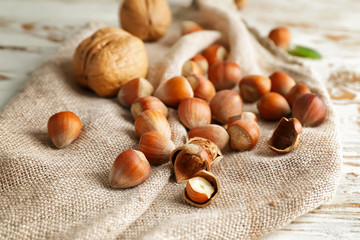 Tasty hazelnuts and walnuts on table