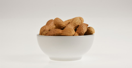 Peanuts in a bowl isolated on neutral background