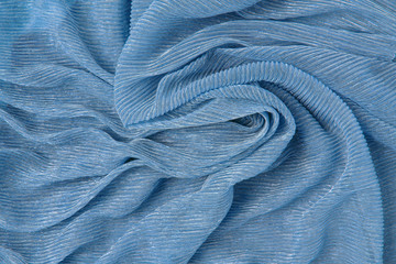 Background of corrugated silk classic blue color twisted fabric. Abstract background, empty template. Top view.
