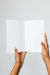 Studio shot of a black woman holding an A5 or folded letter size blank mockup