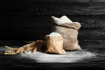 Bags with flour on dark background