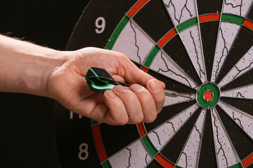 Man taking dart out of dartboard, closeup