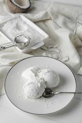 Plate with tasty coconut ice-cream on table