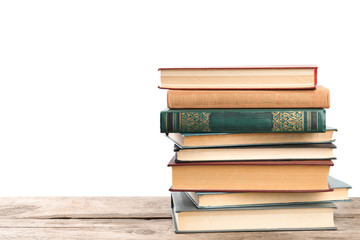 Stack of old vintage books on wooden table against white background