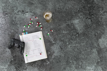 no playing computer games and consuming alcohol and drugs instead of learning, pressure to perform in school while learning to drug and alcohol, marble table with beer, medications, drugs, mathematics