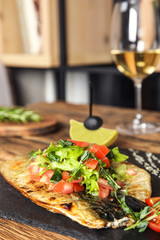 Delicious grilled fish served on wooden table. Space for text